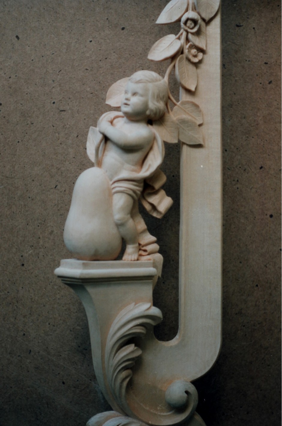 Close up showing left hand frame with pear cherub - pear hand carved mirror jose sarabia cherub