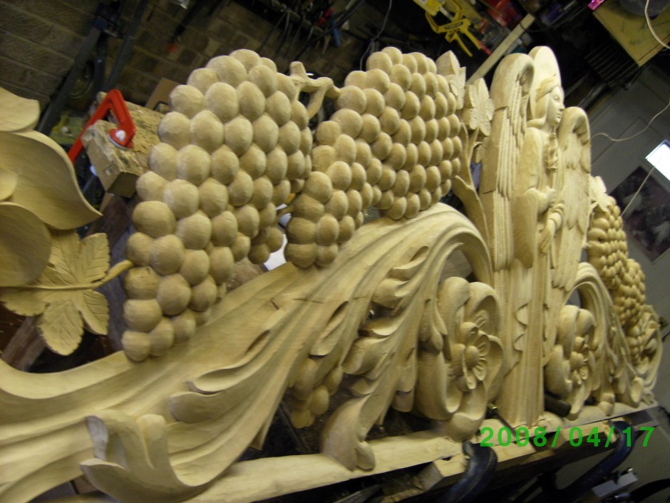 The bedhead, carving in progress in the workshop - bed head grapes leaves angel