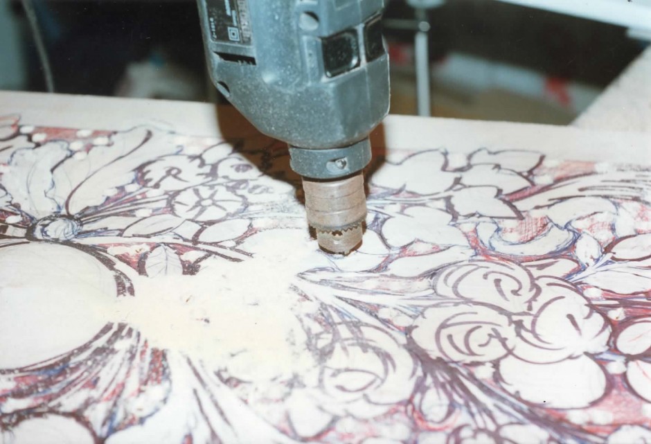 Work begins with drilling open areas of the plaque - drilling wall plaque wood carving
